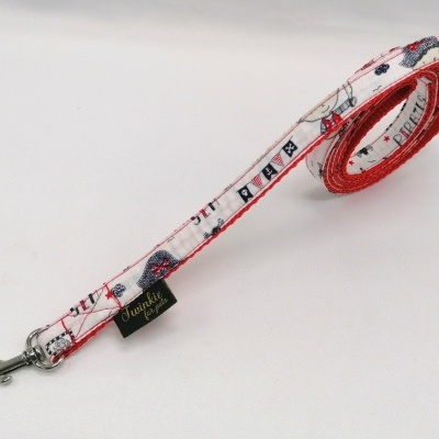 Trela para cão com padrão branco, vermelho e azul e gancho metálico.