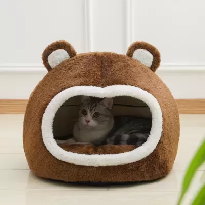 Cama para gato em forma de cabeça de urso castanha e branca com gato dentro