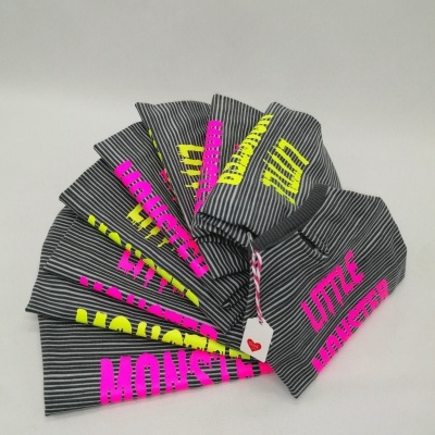 Gorros cinzentos com riscas e texto 'LITTLE MONSTER' em rosa e amarelo.