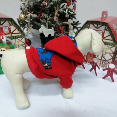 Mannequim de cão com roupa vermelha e cenário natalício