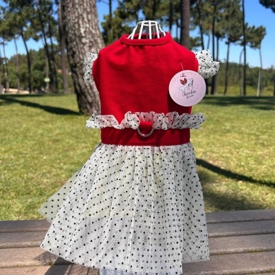Vestido para cão vermelho com saia branca de bolinhas negras em manequim ao ar livre