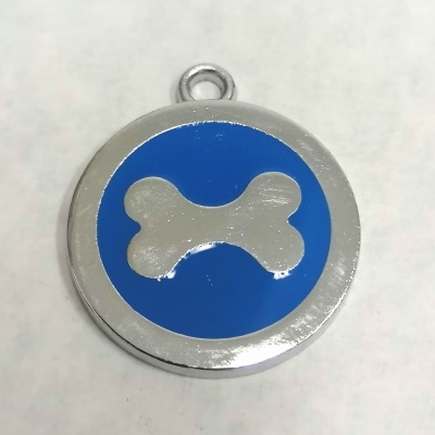Medalha metálica redonda com osso branco sobre fundo azul