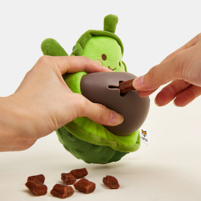 Brinquedo verde para cães em forma de ervilha com cápsula castanha e guloseimas