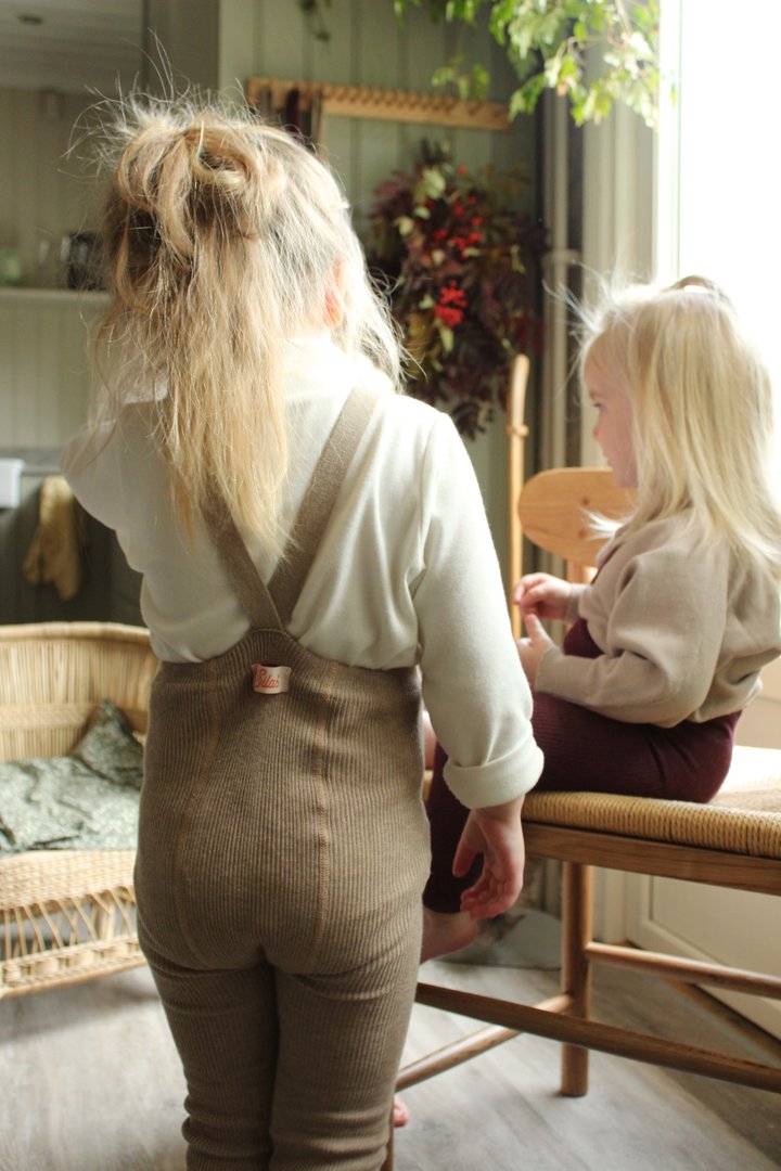 Crianças pequenas em roupas de malha em ambiente interior acolhedor