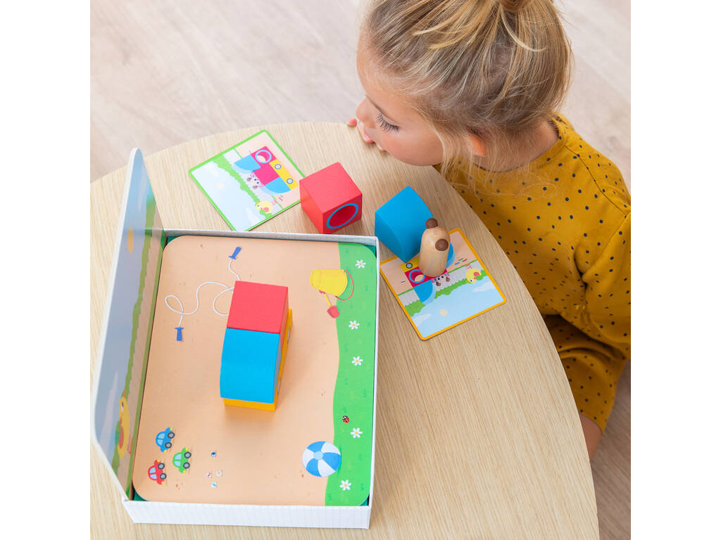 Criança a jogar com blocos de madeira coloridos e cartas num tabuleiro de praia
