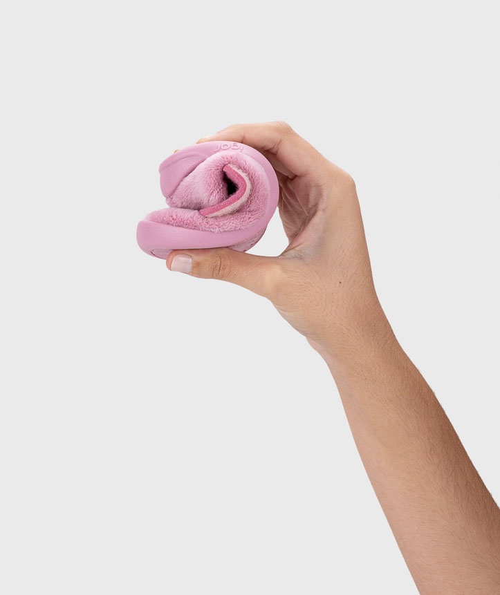 Mão masculina segurando tecido cor-de-rosa enrolado