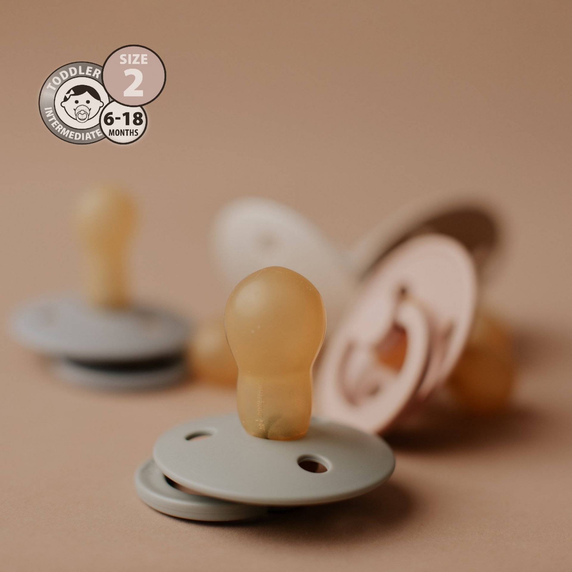 Chupetas de silicone translúcido com base colorida em tons neutros