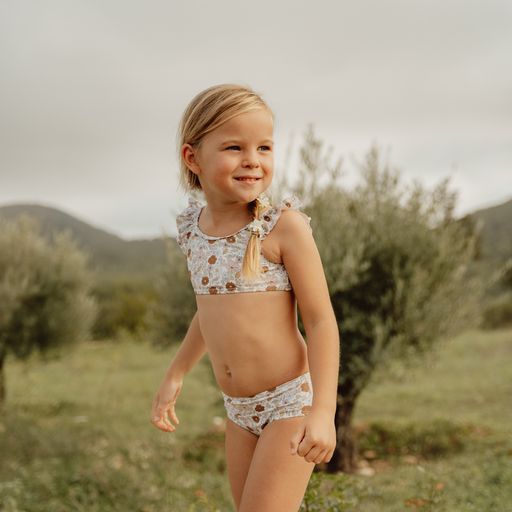 Menina criança com biquíni estampado de bolinhas em ambiente natural