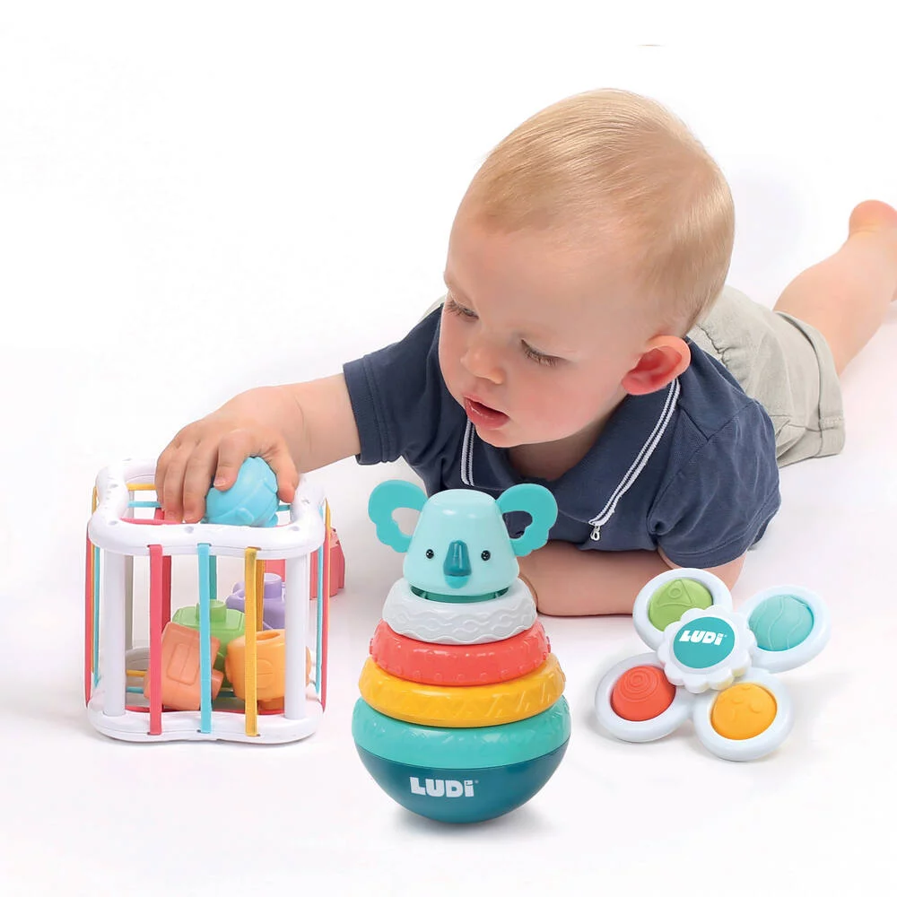 Bebé a brincar com brinquedos coloridos em fundo branco