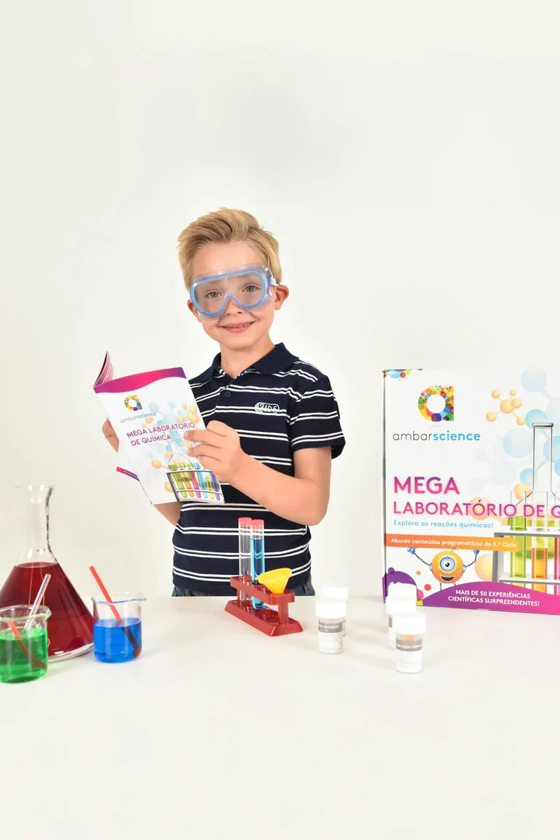 Criança com óculos de proteção e kit de laboratório de ciência colorido