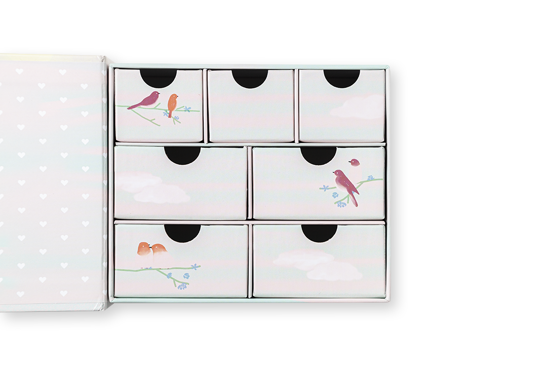 Caixa branca com sete gavetas pequenas decoradas com pássaros e ramos florais