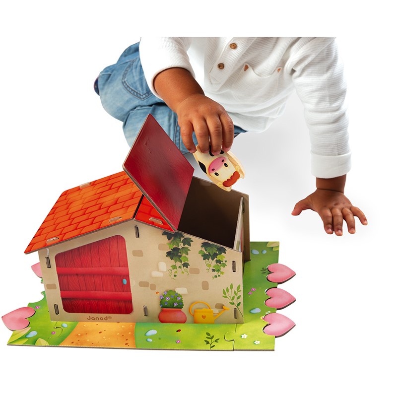 Brinquedo de madeira casa com telhado vermelho e criança a brincar