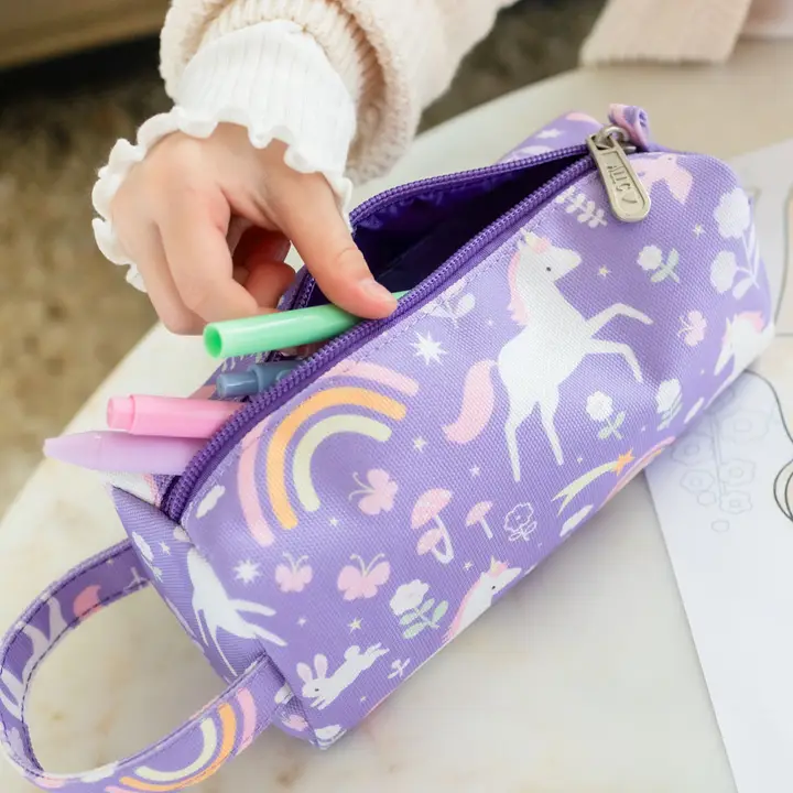 Estojo lilás com padrão de unicórnios e arco-íris a abrir com canetas coloridas dentro e mão feminina