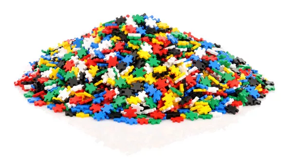 Montão de peças de construção coloridas em plástico sobre fundo branco