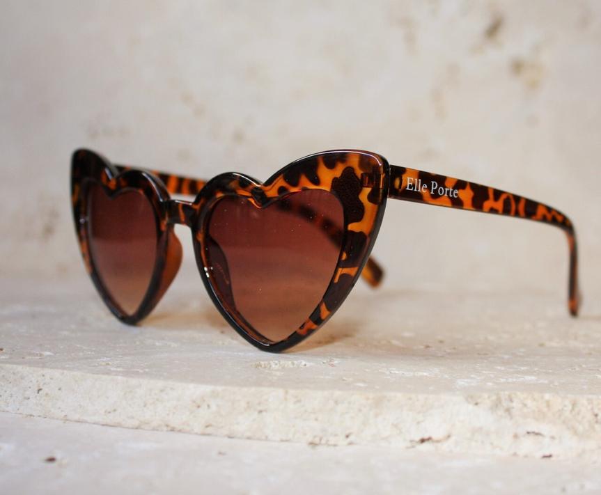 Óculos de sol com armação tartaruga castanha e lentes castanhas em formato de coração