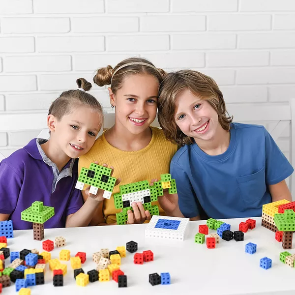 Crianças brincando com blocos de construção coloridos na mesa branca