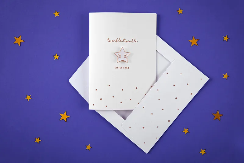 Cartão branco com texto e estrela dourada sobre fundo azul com estrelas amarelas