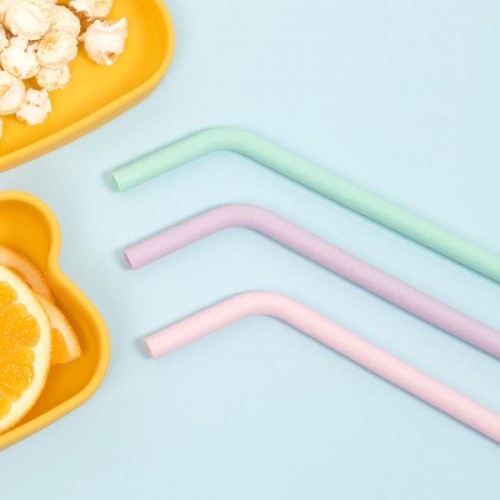 Três canudos coloridos e dois pratos amarelos com laranja e pipocas