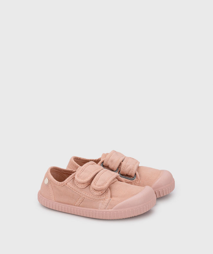 Sapatilhas cor rosa com fechos de velcro sobre fundo branco