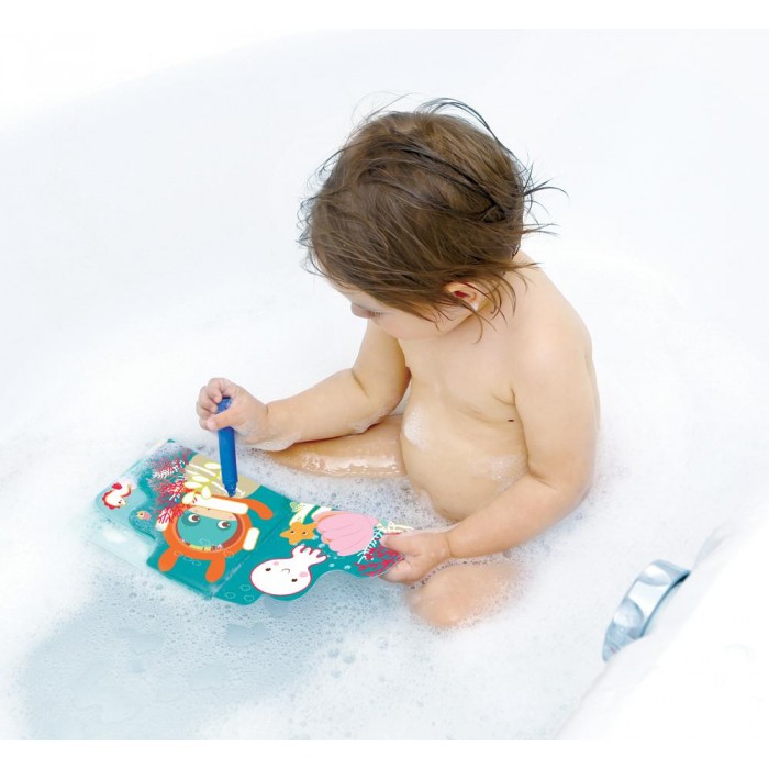 Bebé a brincar com brinquedo colorido numa banheira cheia de espuma