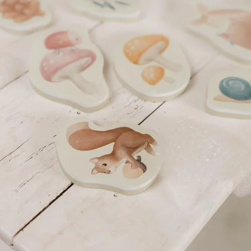 Peças decorativas de cogumelos coloridos e esquilo sobre superfície branca