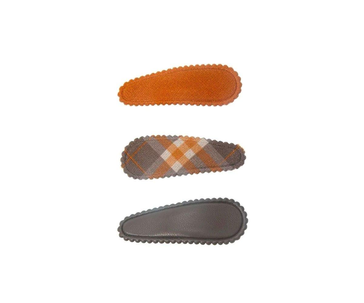 Três molas de cabelo coloridas em fundo branco