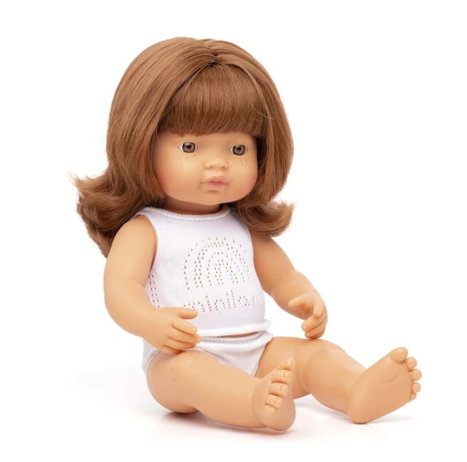 Boneca de vinil castanha com body branco e padrão de arco-íris perfurado