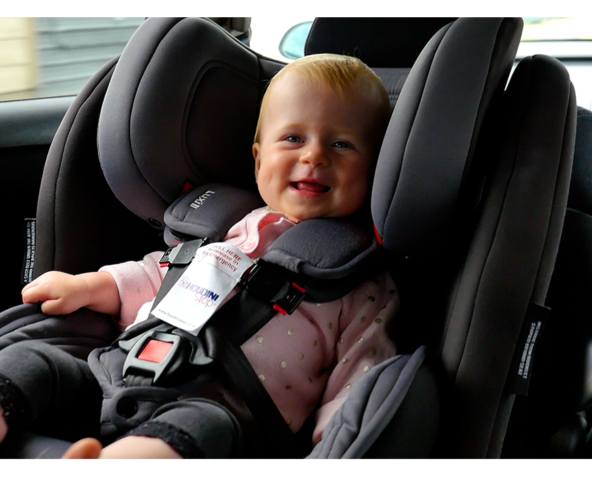 Bebé em assento de carro cinzento escuro com cinto de segurança acolchoado