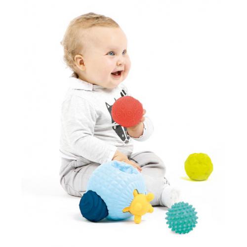 Bebé sentado com várias bolas texturizadas coloridas