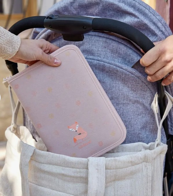 Mala de maternidade rosa com raposa a ser colocada numa cadeira de passeio cinza.