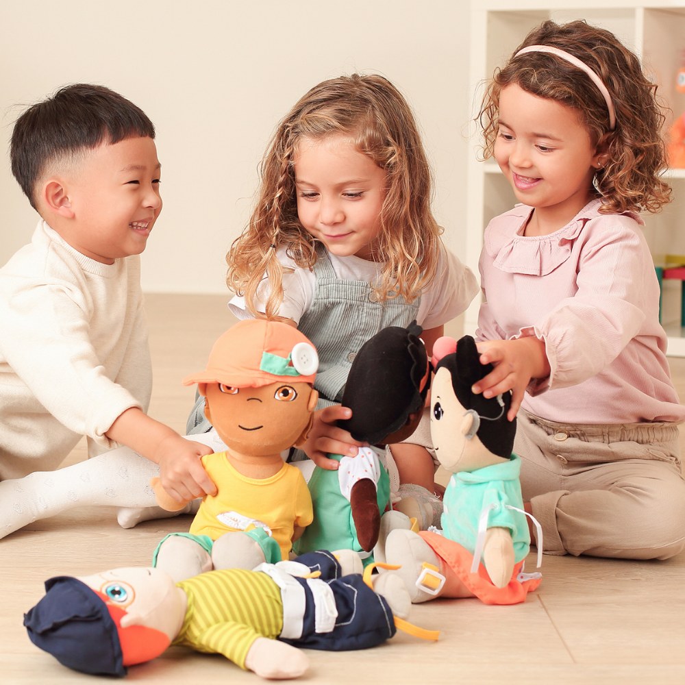 Crianças a brincar com bonecos de tecido coloridos no chão