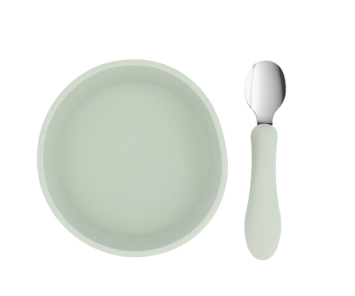 Prato redondo branco com colher de cabo branco e colher metálica