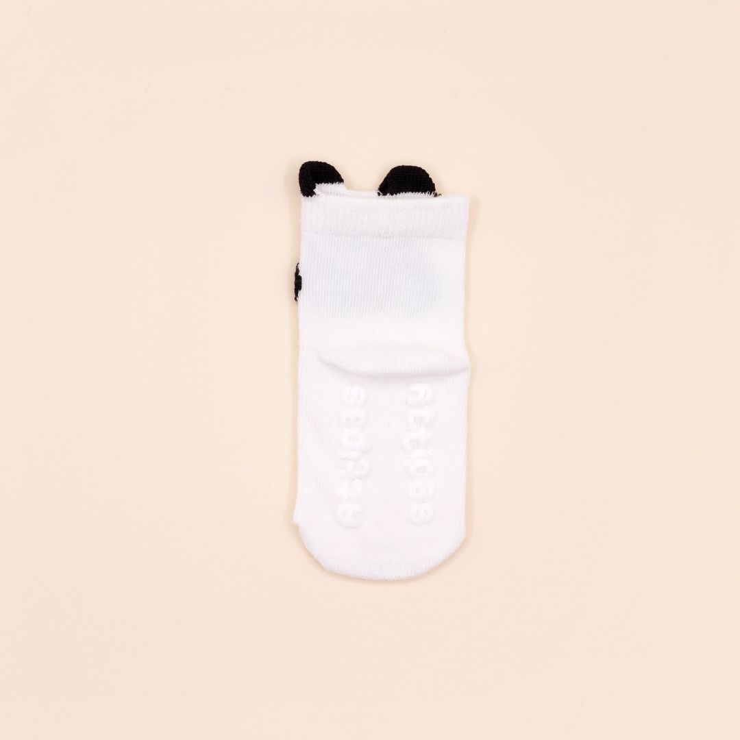 Meia branca para bebé com detalhes pretos e sola antiderrapante