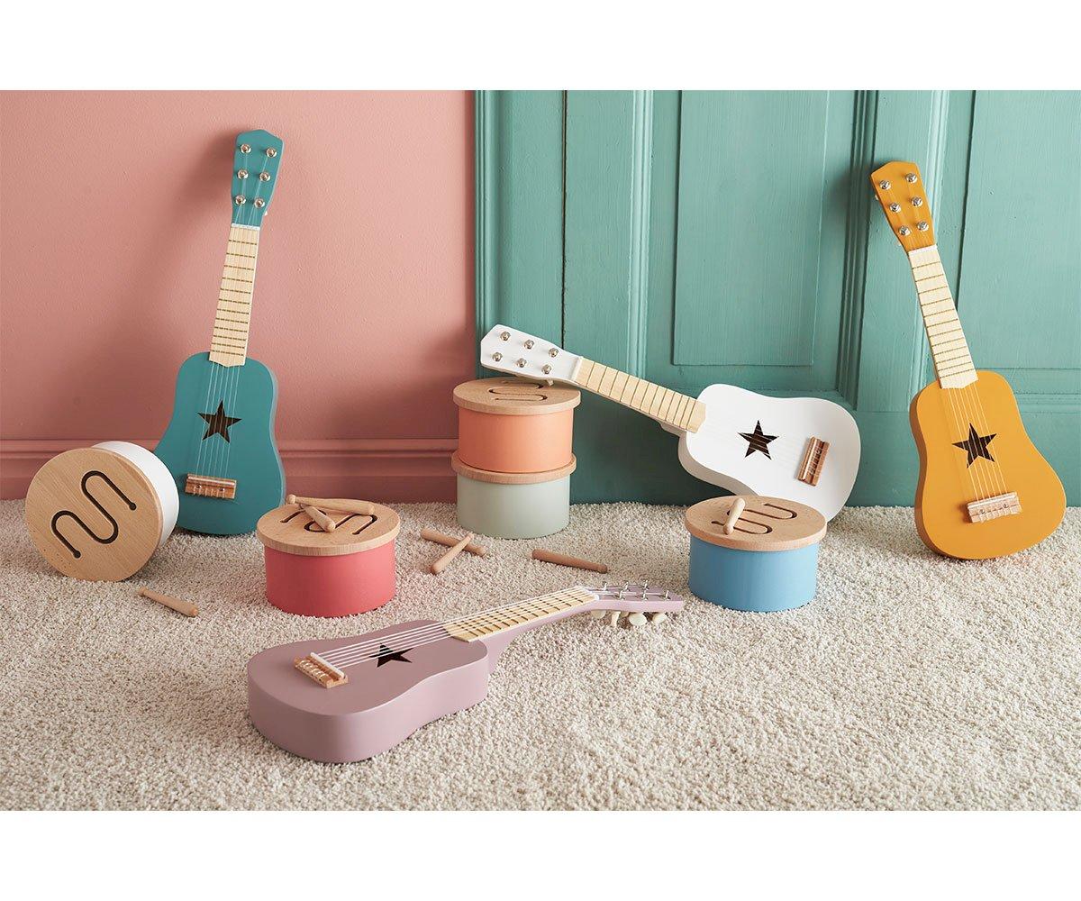 Guitarras de madeira coloridas e tambores para crianças sobre tapete