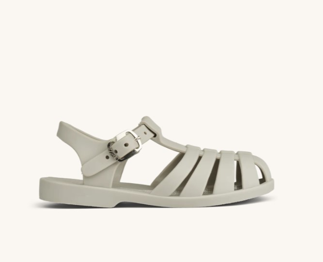 Sandália branca tipo jelly em plástico com fivela ajustável.