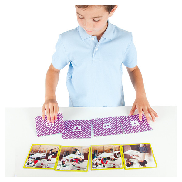 Criança a jogar com cartas de padrão roxo e branco em mesa branca