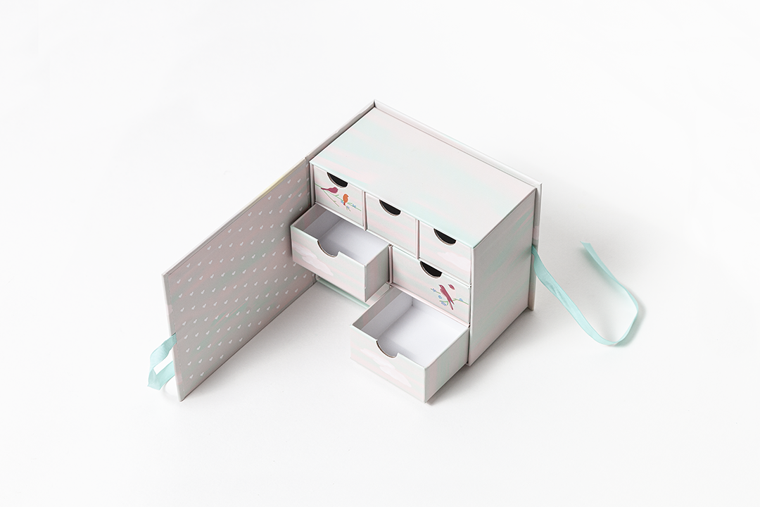 Caixa organizadora branca de papelão com gavetas e laço azul claro
