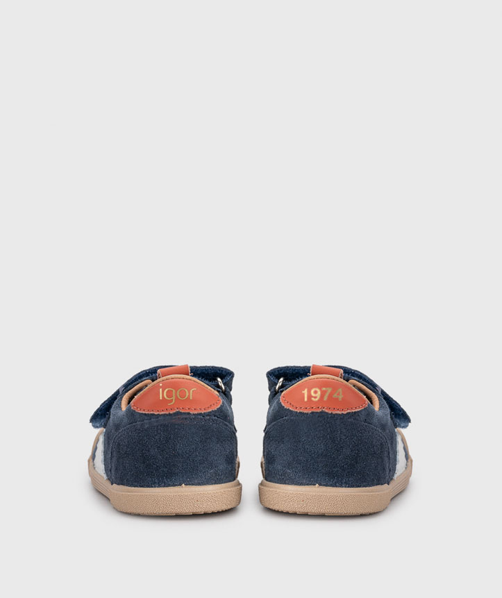 Par de sapatilhas de criança azuis com sola bege e etiquetas castanhas com texto