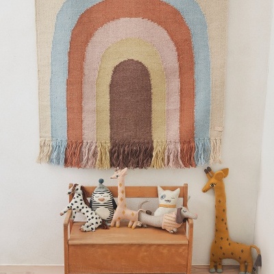 Tapete de parede colorido e banco infantil com bonecos de pelúcia de animais