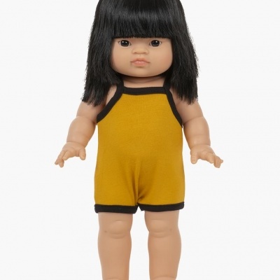 Boneca com macacão amarelo e cabelo preto em fundo branco