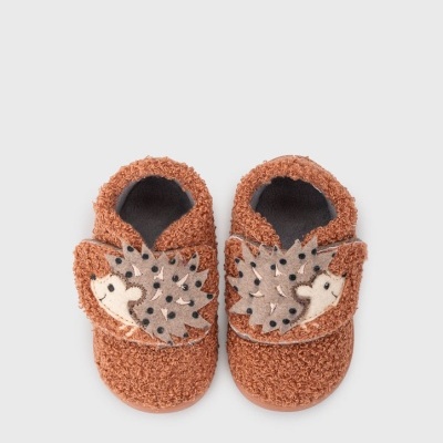 Sapatinhos de bebé castanhos com leões decorativos cinzentos e pretos.