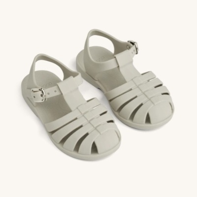 Sandálias fisher brancas com fecho de fivela sobre fundo branco