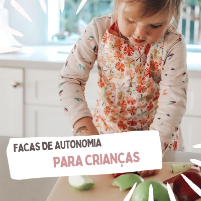 Criança a usar avental a cortar maçãs verdes numa cozinha branca