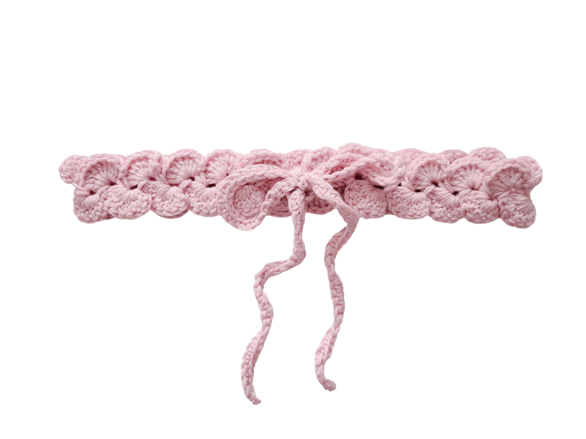 Cinto ou faixa rosa em croché com laço sobre fundo branco