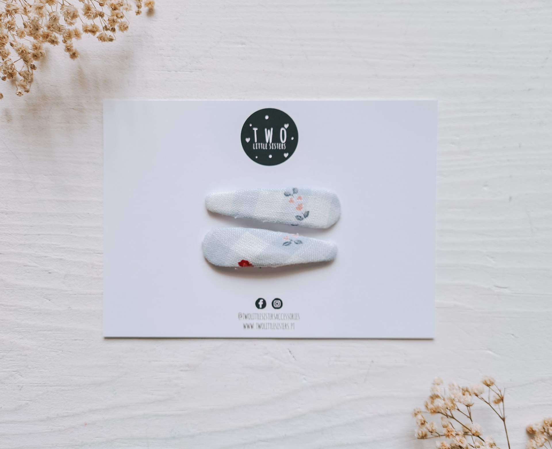 Presilhas de cabelo brancas com padrões florais em cartão branco