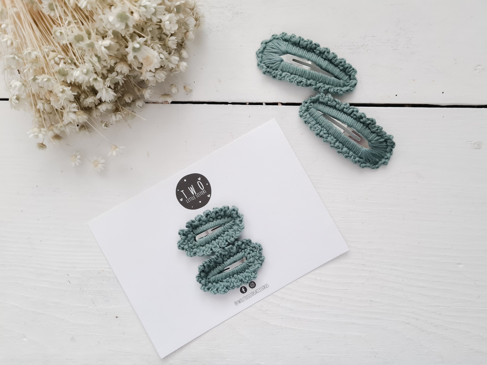 Conjunto de molas de cabelo verdes com textura em cartão branco e molas soltas na superfície