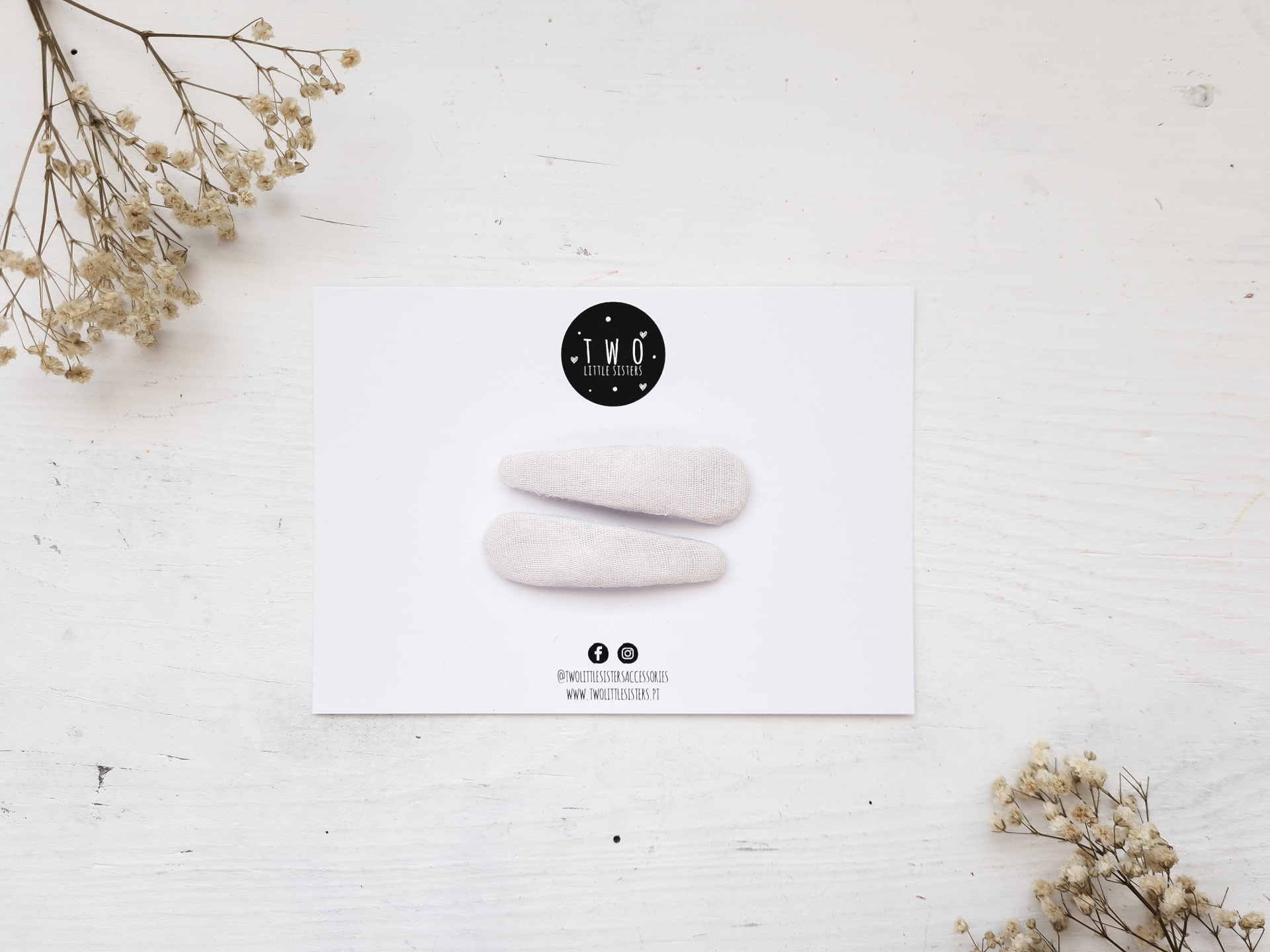 Cartão branco com prendedores de cabelo brancos e flores secas em fundo branco