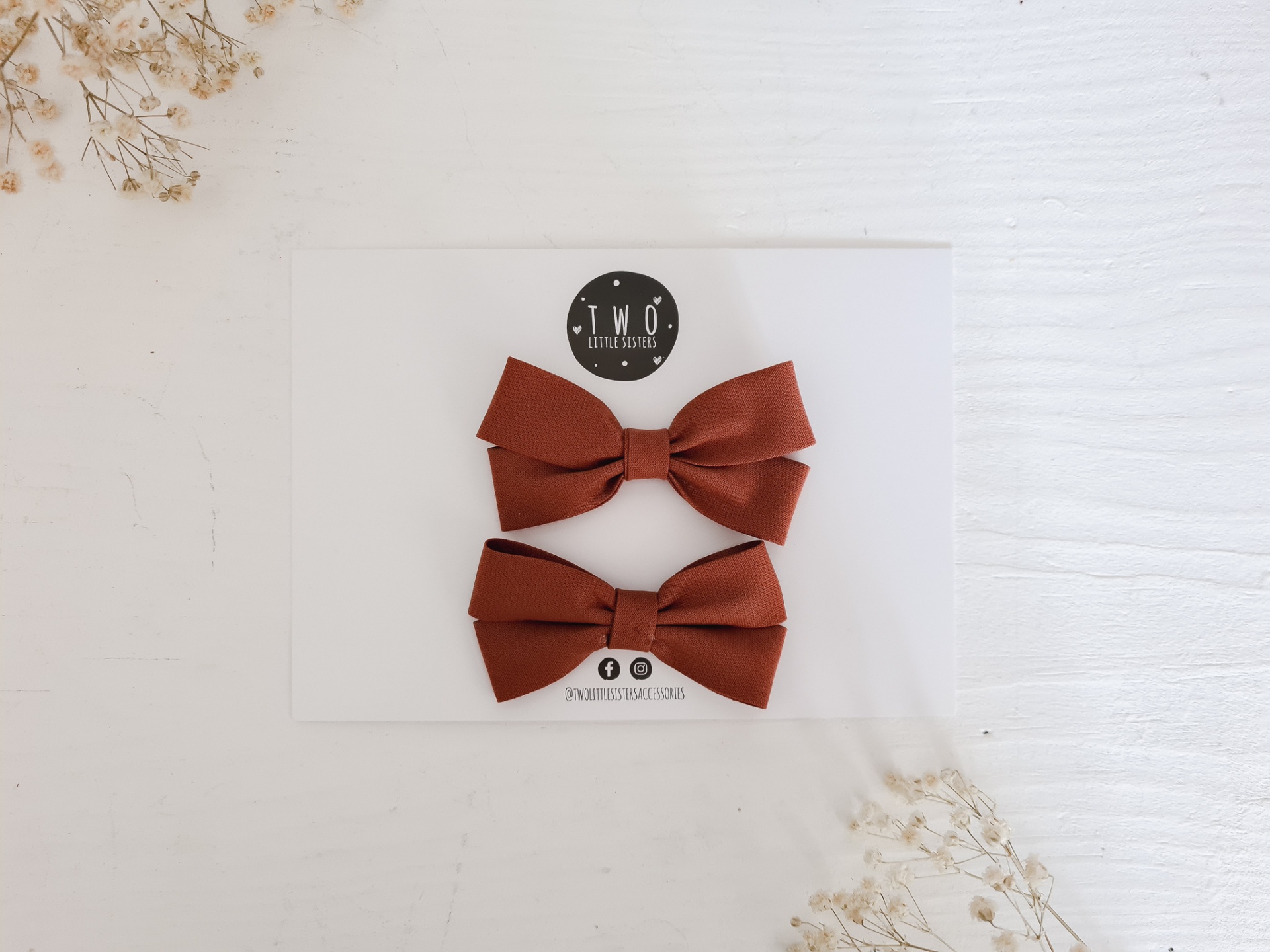 Dois ganchos de cabelo em forma de laço castanho em embalagem branca com logo T.W.O accessoires