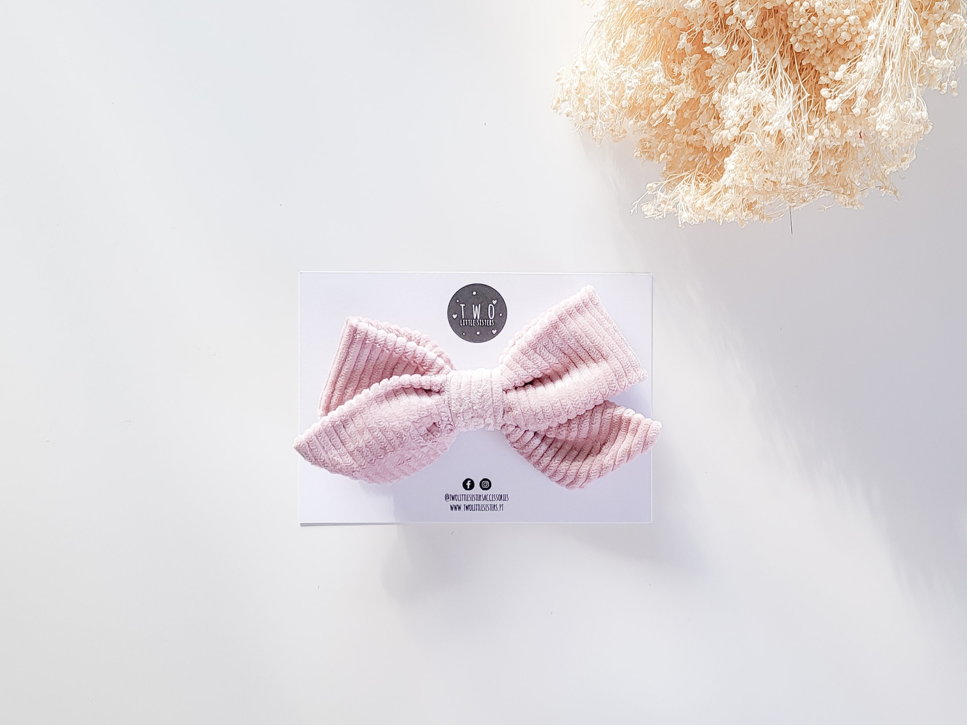 Laço cor-de-rosa em veludo canelado e cartão branco com logótipo