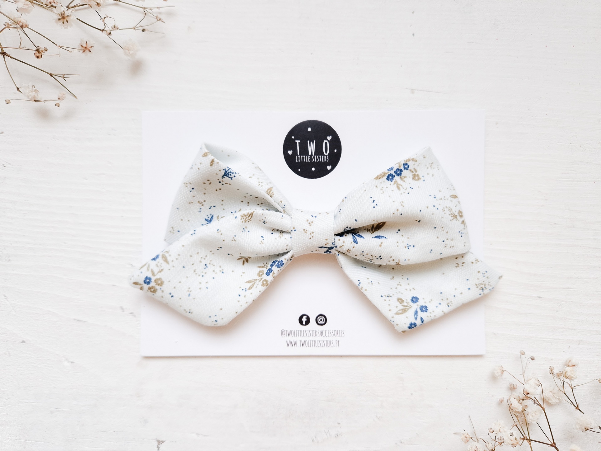 Laço branco com padrão azul sobre cartão com logótipo Two Handmade